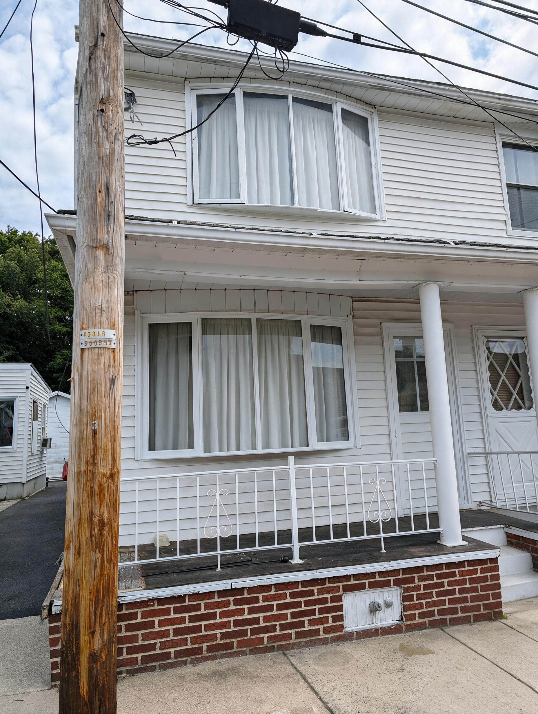 Front of house with bay windows and porch railing