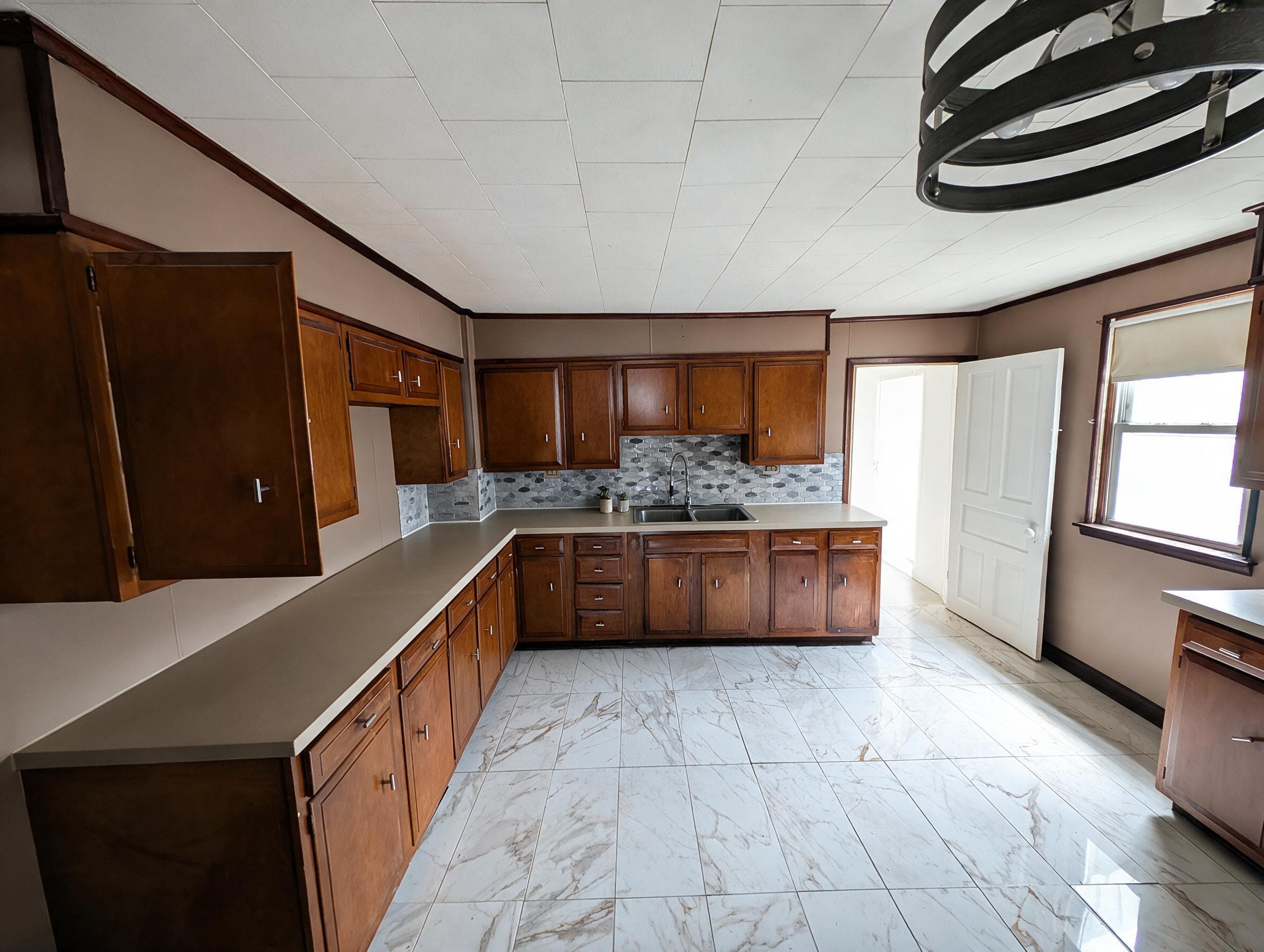 Large kitchen with wood cabinets and marble tile floor