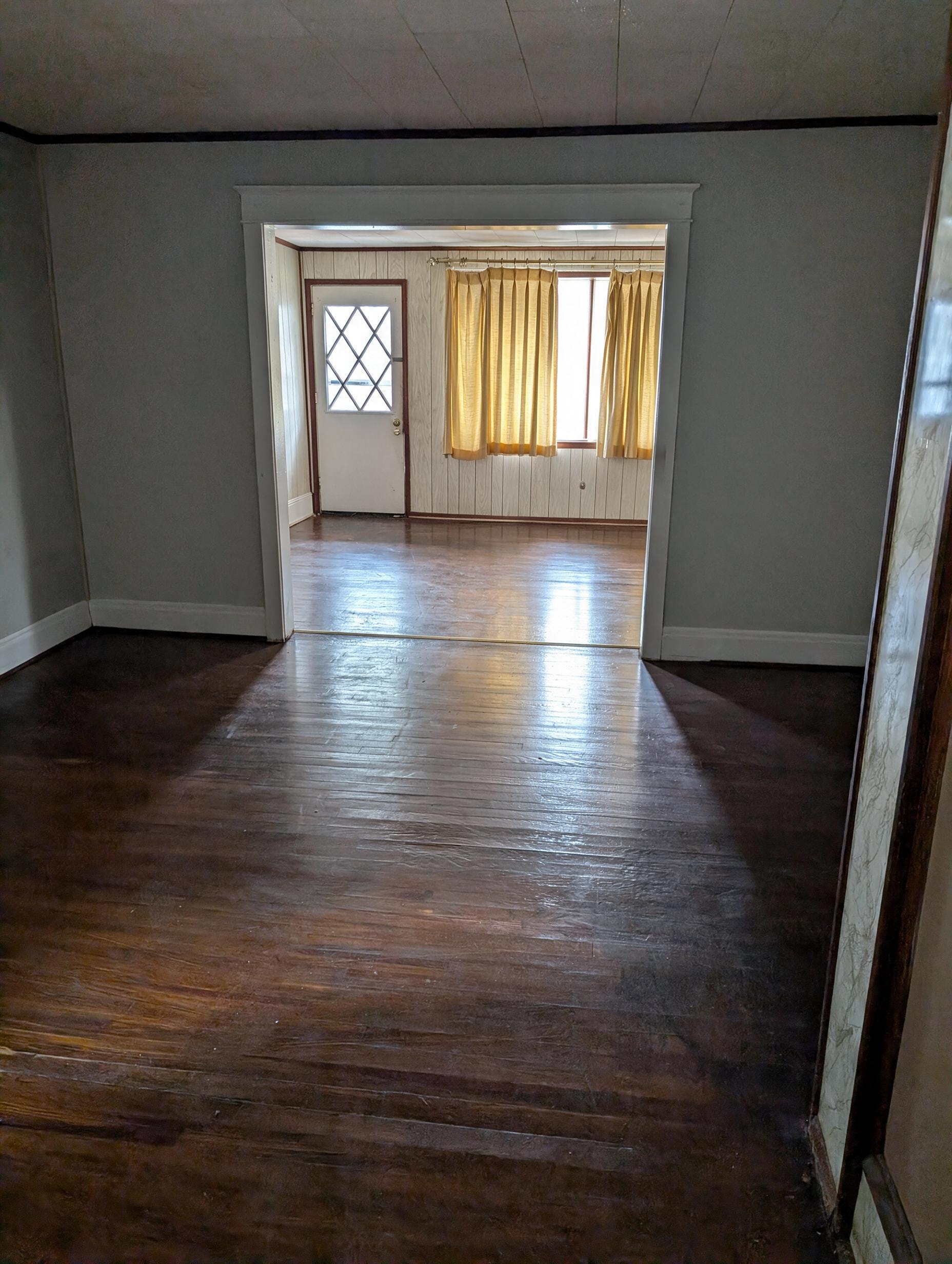 Living room with dark hardwood floors and gold curtains