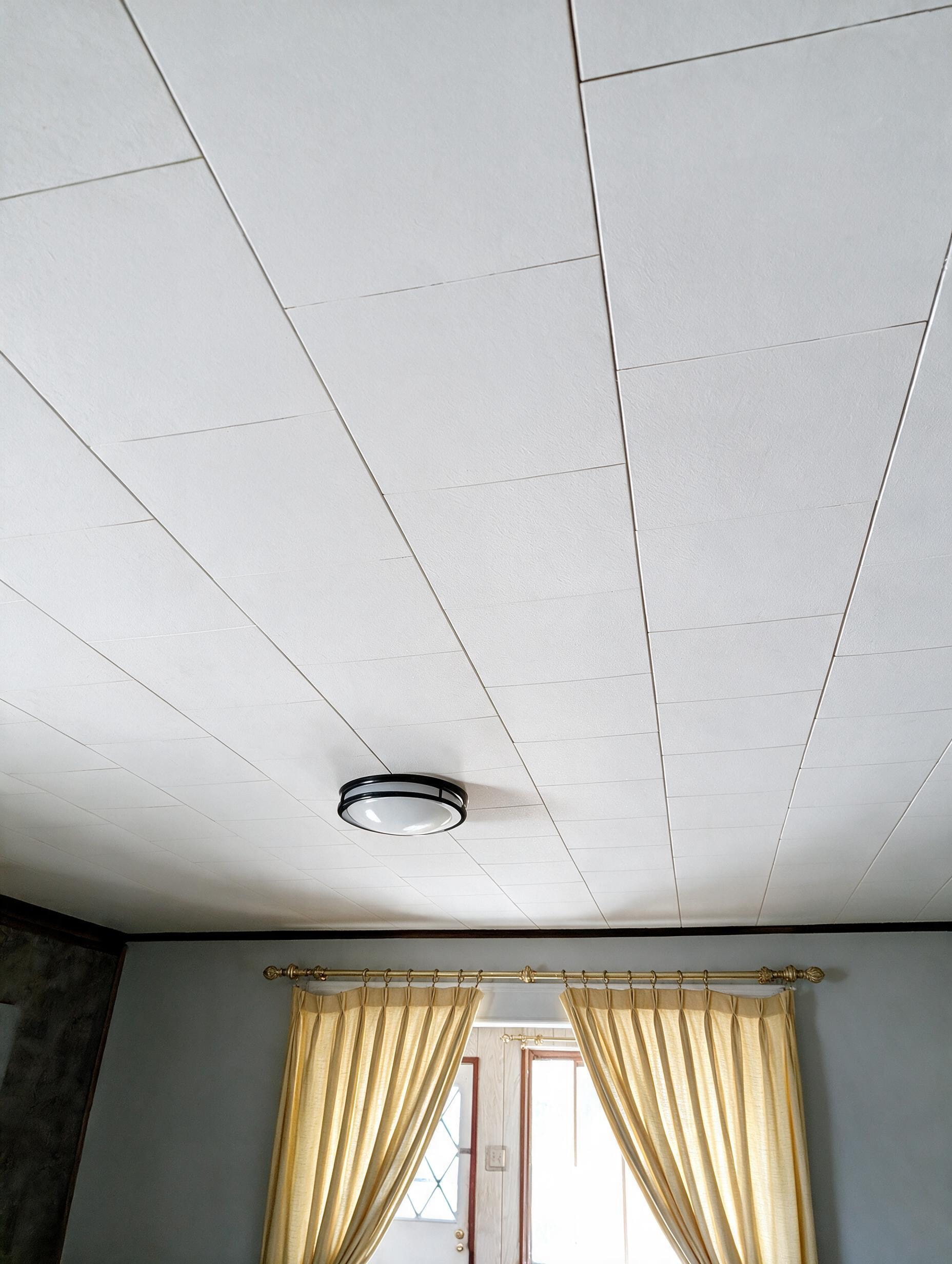 Ceiling with flush mount light and gold curtains
