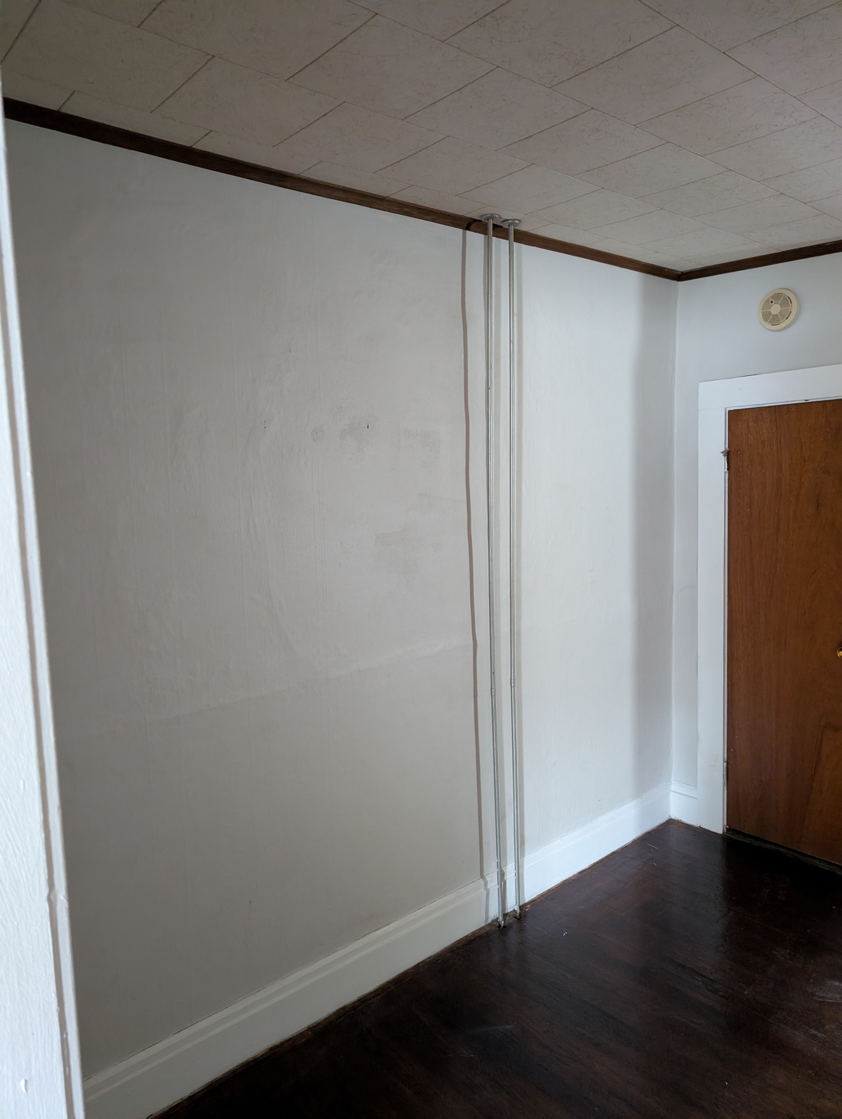 Empty room with white walls and dark hardwood floors