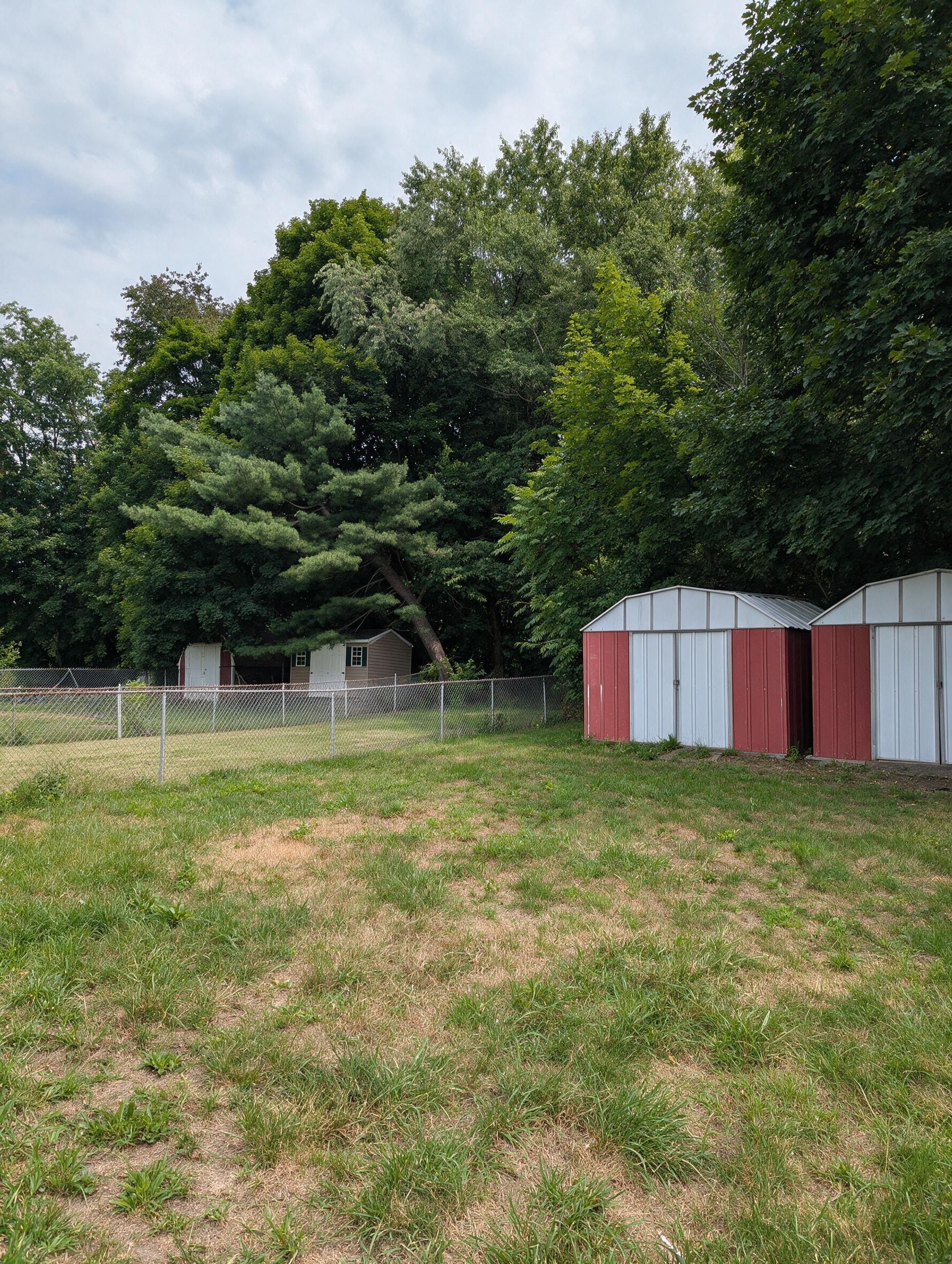 Backyard with red and white storage sheds