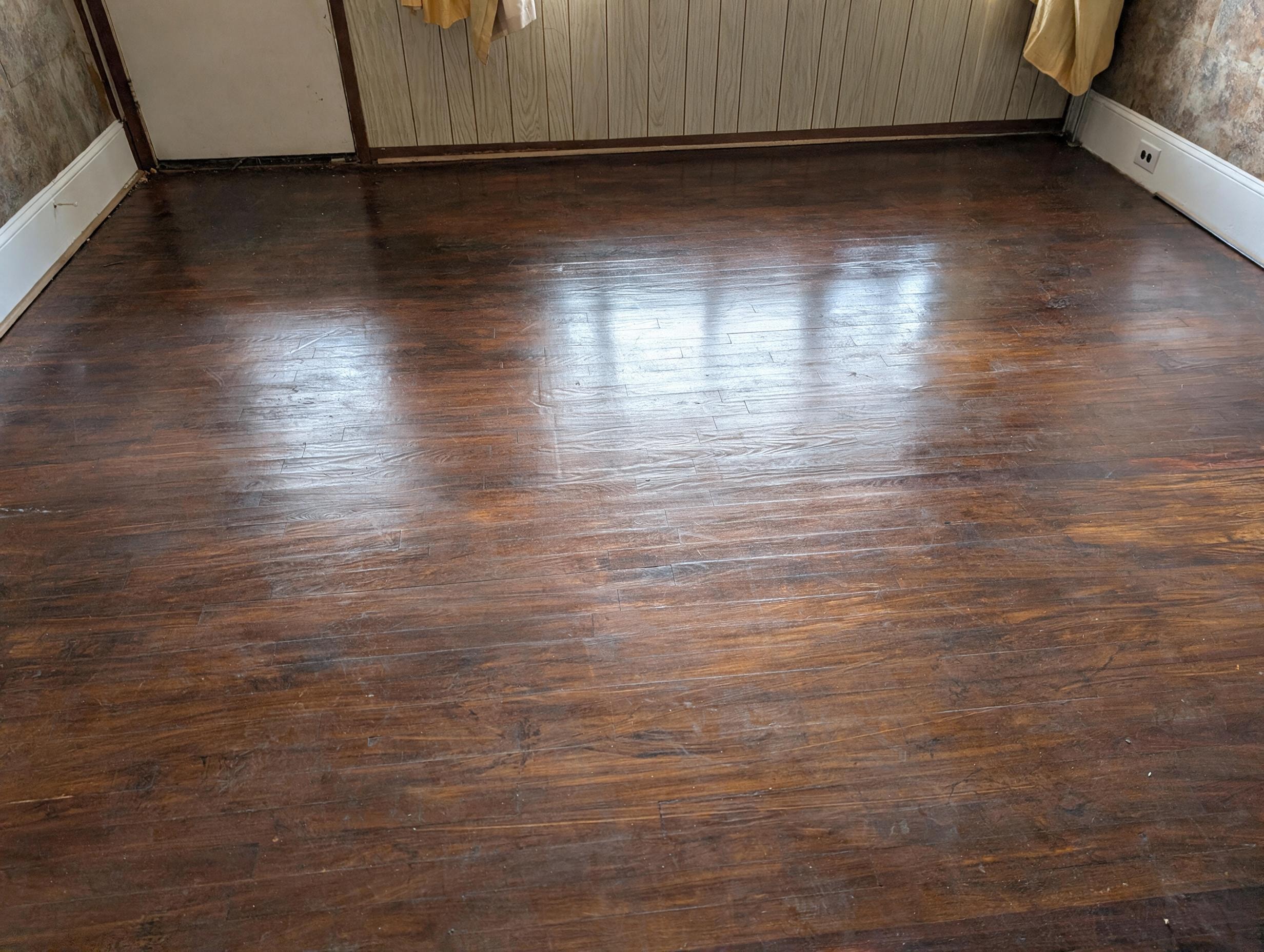 Dark hardwood floor close-up with wood paneling and closet doors