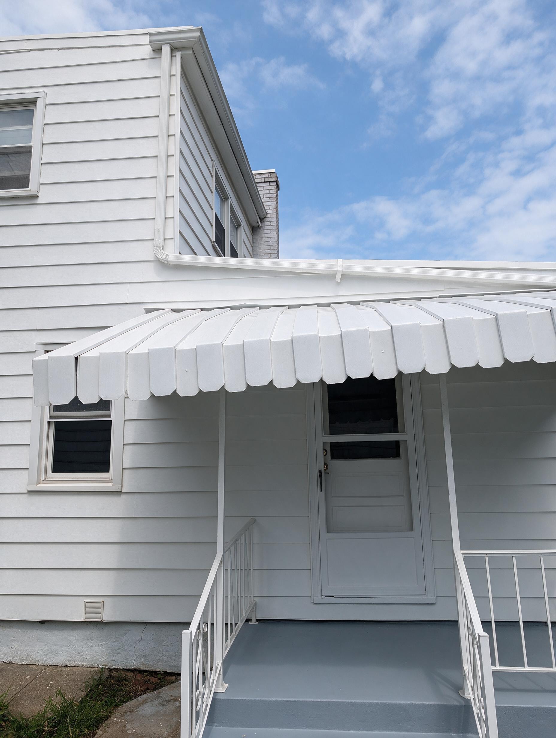 Back entrance with white awning and steps